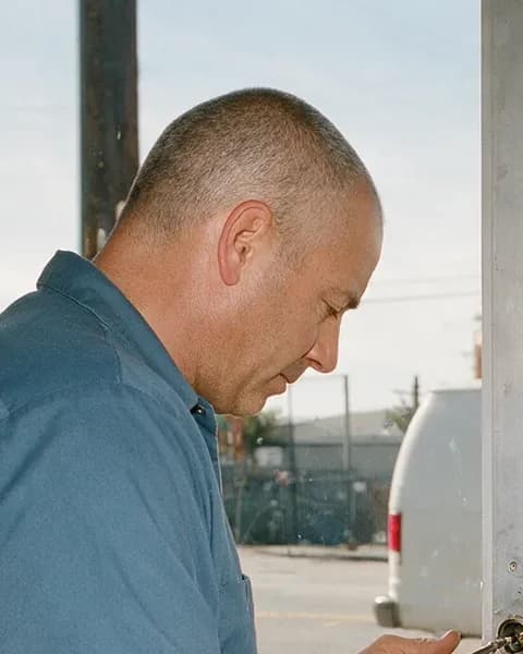 Dominic Okafor, owner of Eden Locksmith, working the lock on a storefront door